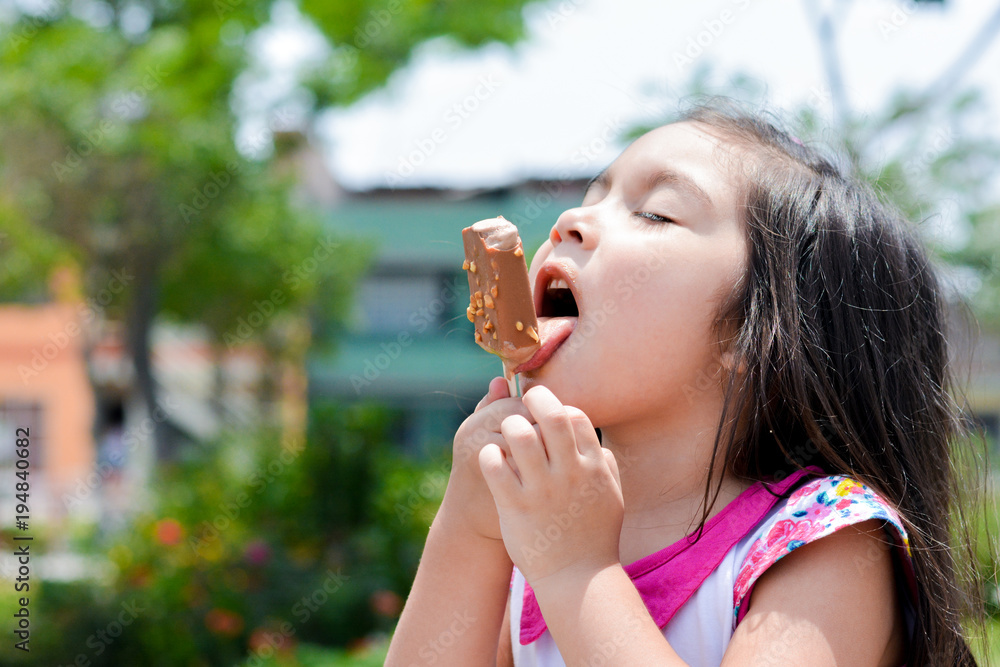 Latin kid eating ice-cream in the summer park. Latin kid eating ice-cream in the summer park.