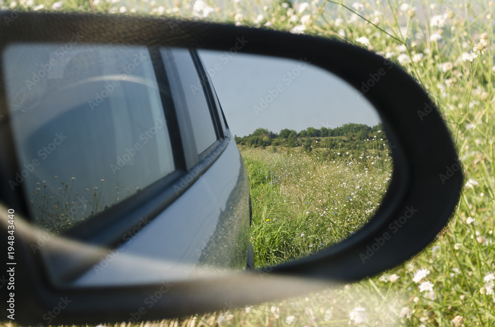 Side rear-view mirror in the morning on the road