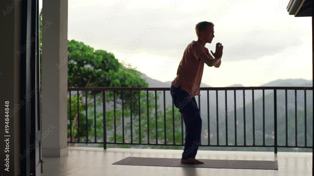 Man practice tree yoga pose at balcony at sunrise rapid slow motion Man practice tree yoga pose at balcony at sunrise rapid slow motion