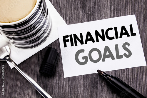 Handwriting Announcement text showing Financial Goals. Business concept for Income Money Plan written on sticky note paper on the wooden wood background. With marker and coffee. Office top view. photo