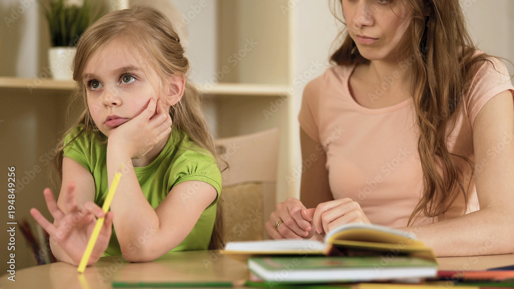 Little daughter ignoring mother making her to do homework, homeschooling Little daughter ignoring mother making her to do homework, homeschooling