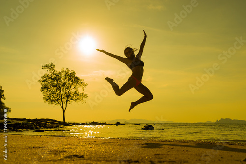 woman jumping on the tropical beach in Thailand