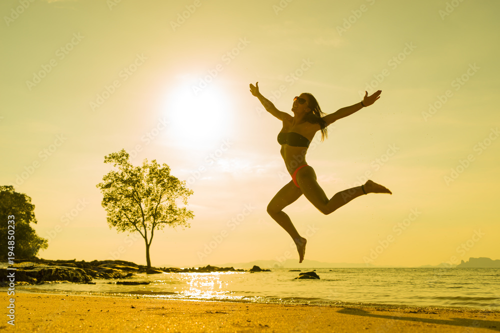 woman jumping on the tropical beach in Thailand woman jumping on the tropical beach in Thailand