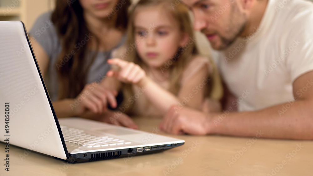 Family using laptop for shopping, booking tickets online or viewing pictures Family using laptop for shopping, booking tickets online or viewing pictures