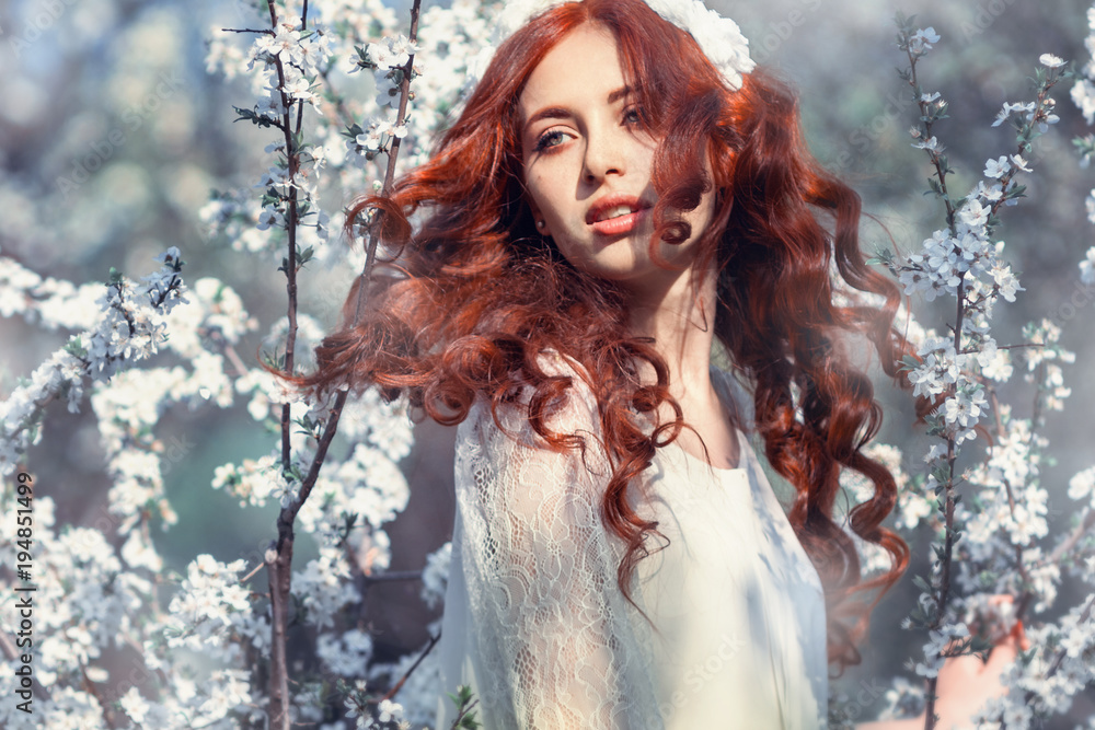 Beautiful girl smiling in the garden with white flowers Beautiful girl smiling in the garden with white flowers