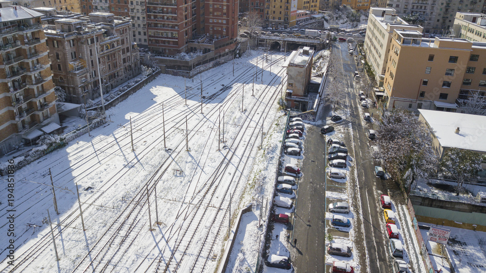  Aerial view of railroad section covered by snow. The tracks and rails are submerged by snow falling in Rome during the cold winter. The movement of metropolitan trains is blocked.