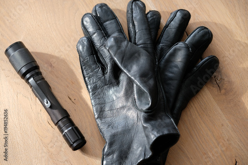 Glove and flashlight at the wood background