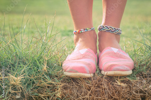 Canvas Print Detail of a young woman's shoes and anklet outdoors.