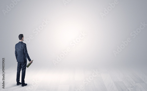 Man with object in his hand in an empty space