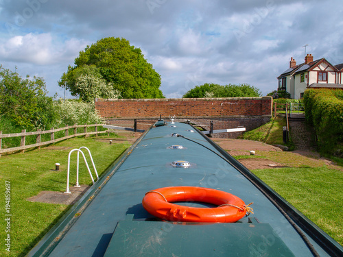 Fototapeta Helmsman view of a narrowboat in a canal lock in the upper position befor discharching the lock chamber