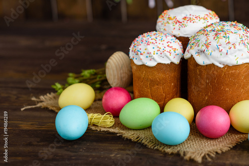Easter cake and colorful eggs on a wooden table. It can be used as a background