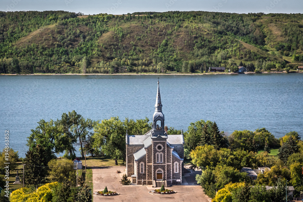 quaint stone church sitting next to a blue lake quaint stone church sitting next to a blue lake
