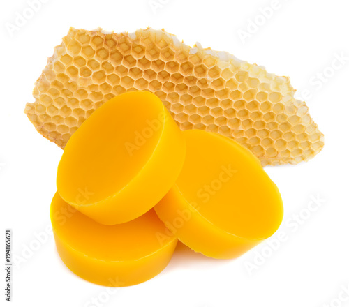 Pieces of natural beeswax and a piece of honey cell are isolated on a white background. Beekeeping products. Apitherapy.