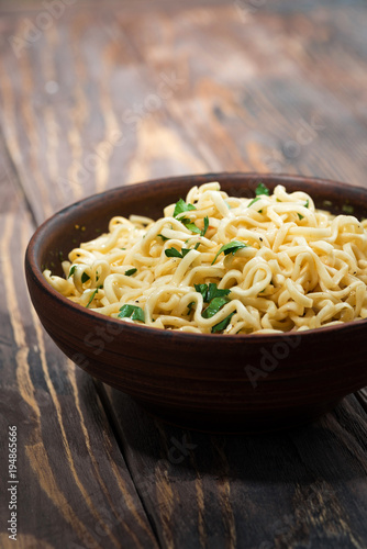 bowl of traditional Chinese noodles on wooden background, vertical