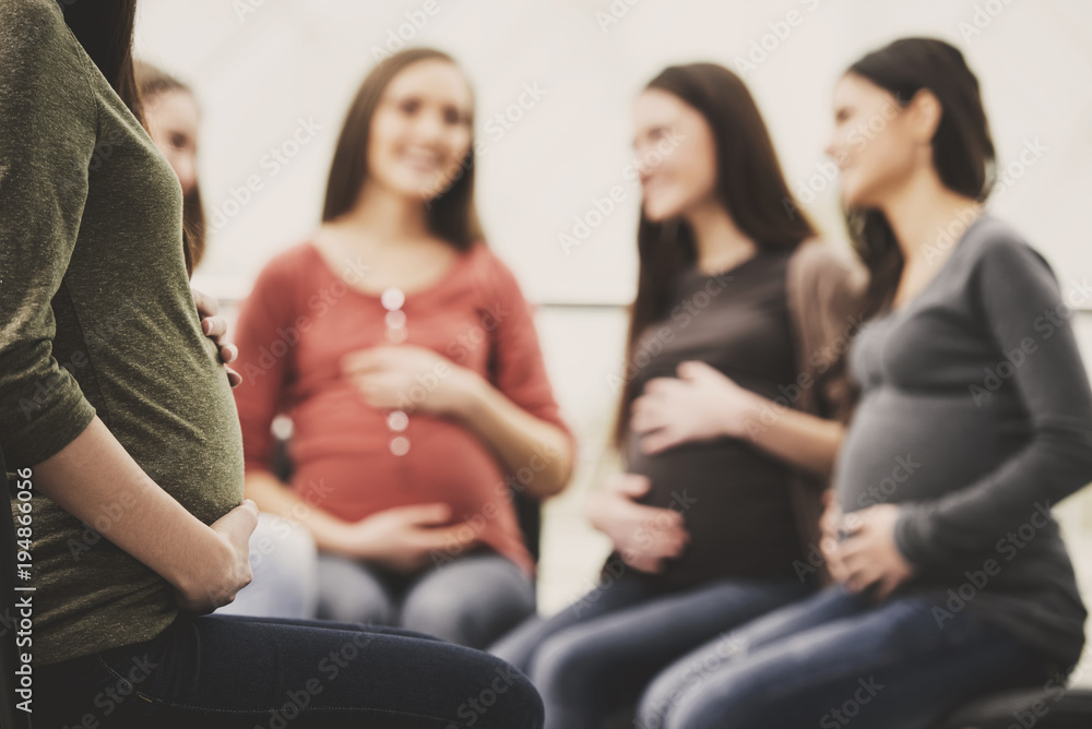 Happy pregnant women are talking together at antenatal class at the hospital - obrazy, fototapety, plakaty 
