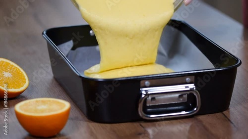 Female hands add dough in a baking dish. Cooking process on kitchen. photo