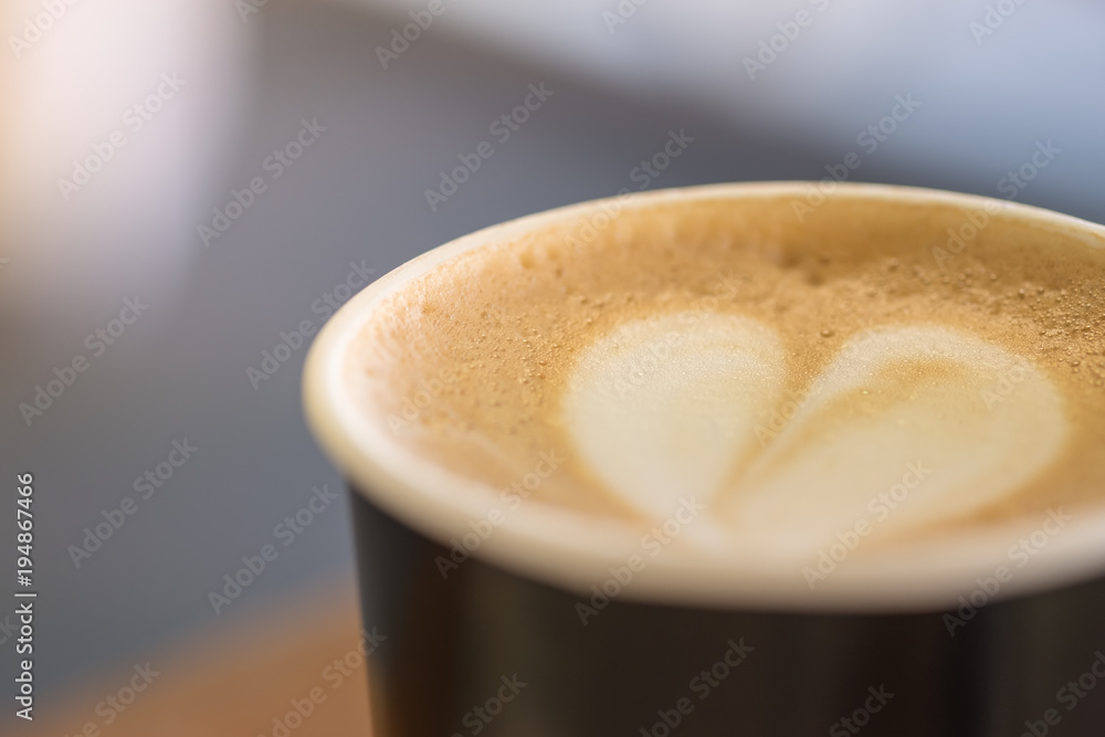 Close up of paper cup of hot coffee latte with milk foam heart shape. Close up of paper cup of hot coffee latte with milk foam heart shape.