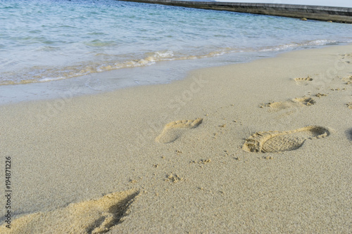 Footprints in the sand of a beach by the Mediterranean sea on the island of Ibiza in Spain  holiday and summer scene