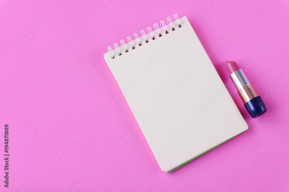 Notepad and lipstick on pink background. Space for text Notepad and lipstick on pink background. Space for text