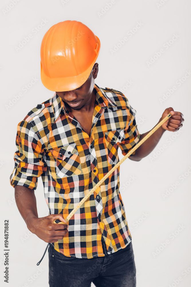 African-American builder uses measuring tape African-American builder uses measuring tape