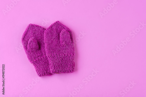 Children's mittens on pink background. Space for text