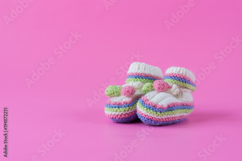 Baby's bootees on pink background. Space for text