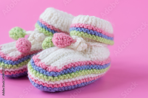 Baby's bootees on pink background. Close up