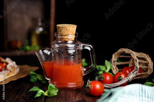 томатный сок в кувшине со свежей зеленью и помидорами