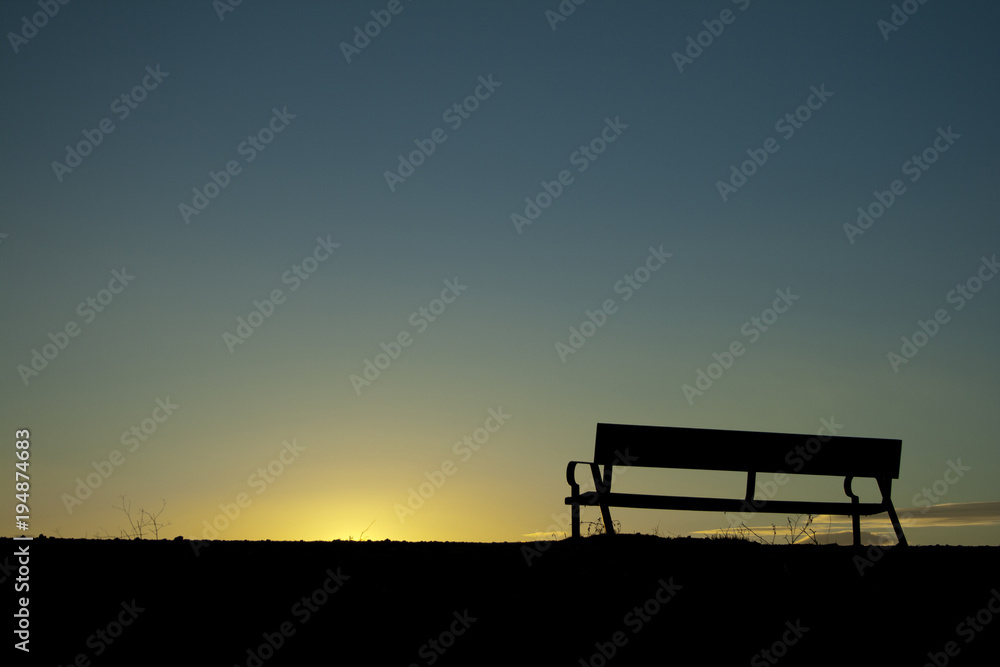 Silhouette chair on Sunset background.