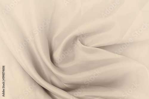 Smooth elegant silk or satin luxury cloth texture. Retro style, beige cream sepia color.