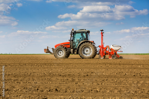 Farmer seeding, sowing crops at field. Sowing is the process of planting seeds in the ground as part of the early spring time agricultural activities.