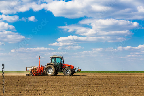 Farmer seeding  sowing crops at field. Sowing is the process of planting seeds in the ground as part of the early spring time agricultural activities.