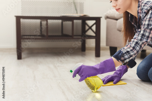 Concentrated woman polishing wooden floor