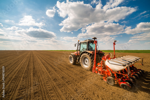 Farmer seeding, sowing crops at field. Sowing is the process of planting seeds in the ground as part of the early spring time agricultural activities. photo
