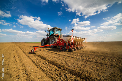 Farmer seeding, sowing crops at field. Sowing is the process of planting seeds in the ground as part of the early spring time agricultural activities.