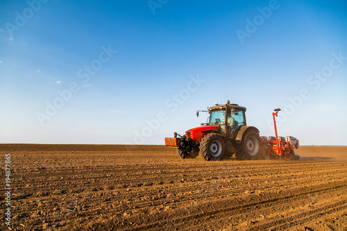 Farmer seeding  sowing crops at field. Sowing is the process of planting seeds in the ground as part of the early spring time agricultural activities.