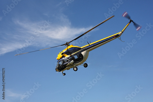 Fototapeta Naklejka Na Ścianę i Meble -  Aircraft - Black-yellow helicopter flight at low height