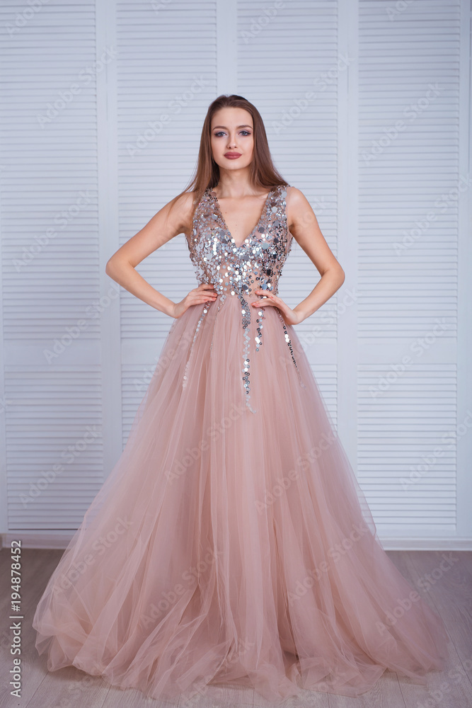 Beauty brunette model woman in evening dress. Beautiful fashion luxury makeup and hairstyle. Seductive girl silhouette in classic interior. Beauty brunette model woman in evening dress. Beautiful fashion luxury makeup and hairstyle. Seductive girl silhouette in classic interior.
