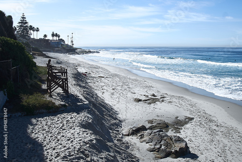 Beautiful view of the oceanfront coastline blue abyss, sandy beach, sunny morning, waves of storm cliff stones rock stone high water, high tide rush, flow, pier. photo