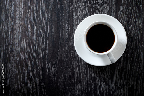 Fototapeta Biała filiżanka czarna gorąca kawa na ciemnym drewnianym tle