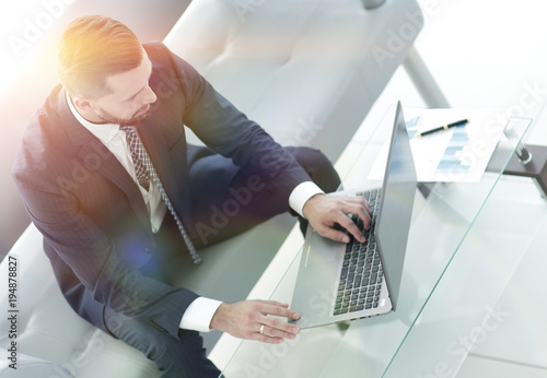 Top view businessman working on laptop with financial graphs photo