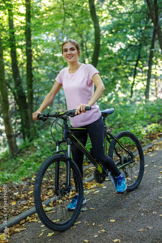 Obraz premium A young woman riding a bike from a steep mountain down. Concept sports, a healthy lifestyle.