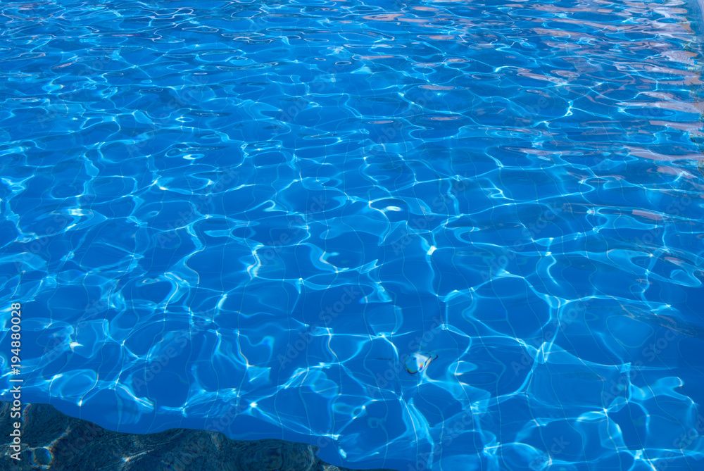 sunlight on pool water. Pool blue water and sun glow. Sunlight on water. Pool floor under water background