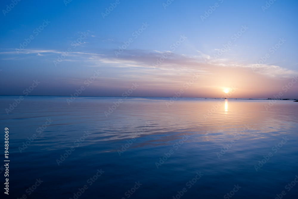 Yellow sunrise on the ocean. Sun under the red sea in the morning. Sunset and reflex on water in the evening. Sunrise and blue sky.