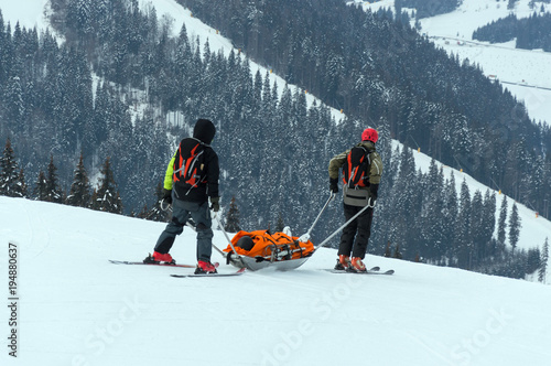 Ski patrol team rescue injured skier with the special emergency sledges in the Carpathian mountains region, Ukraine