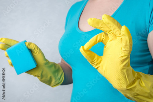 woman in yellow rubber gloves showing gesture OK