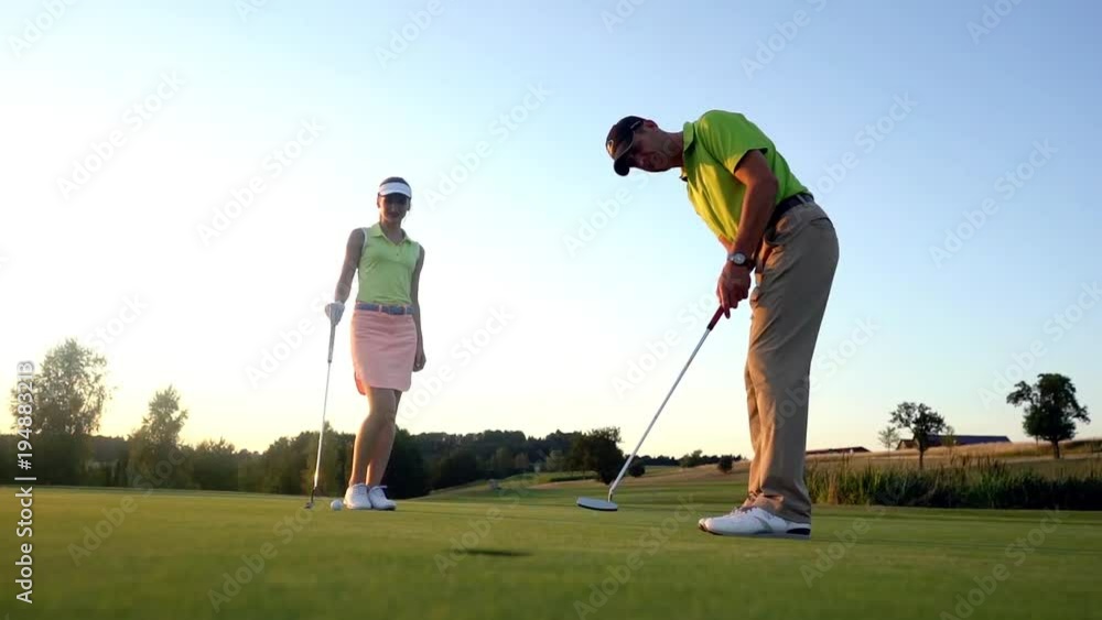 Man ready to hit the golf ball while exercising with his game partner in a modern country club Man ready to hit the golf ball while exercising with his game partner in a modern country club
