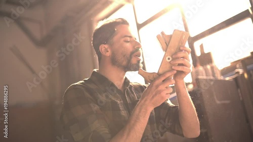 Handsome man in his fourties working with tools and wood at his workplace photo