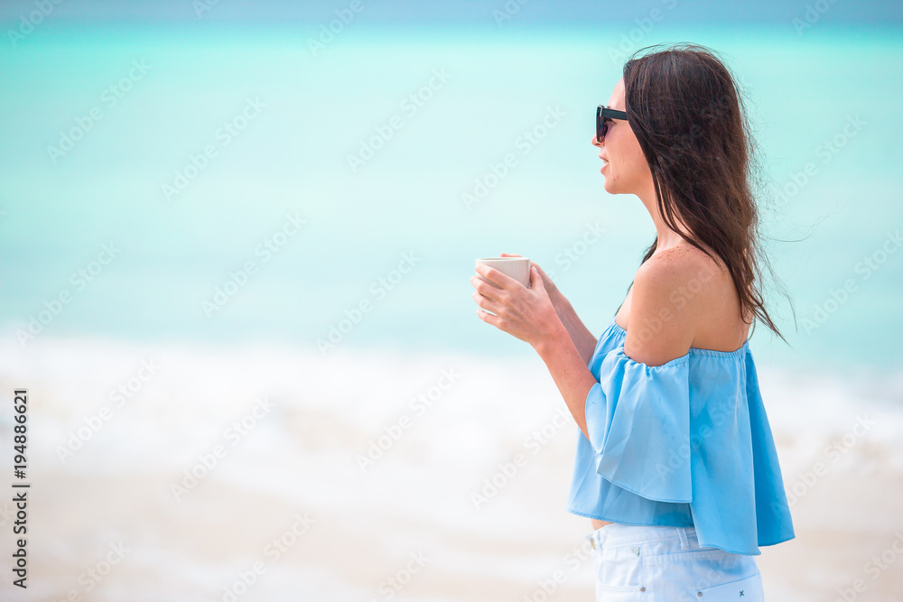 Young beautiful woman having fun on tropical seashore. Happy girl walking at white sand tropical beach