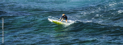 Young Surfer trying the waves in Hawaii, Maui photo